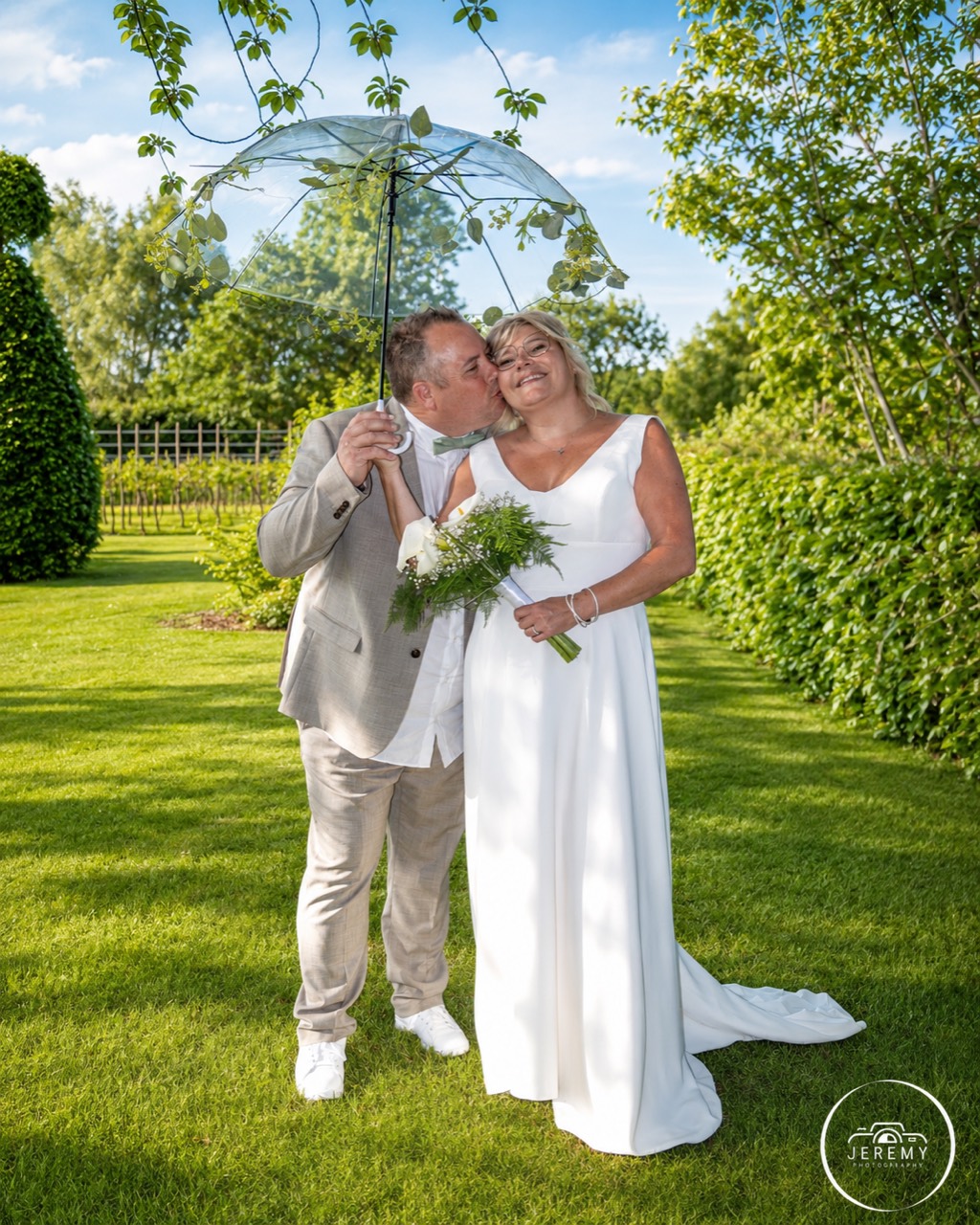Couple de mariés sous une ombrelle transparente
