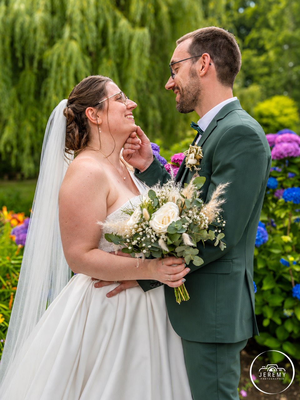 Portrait des mariés dans un jardin fleuri